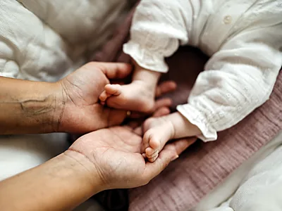 La mano di un neonato nella mano di un genitore